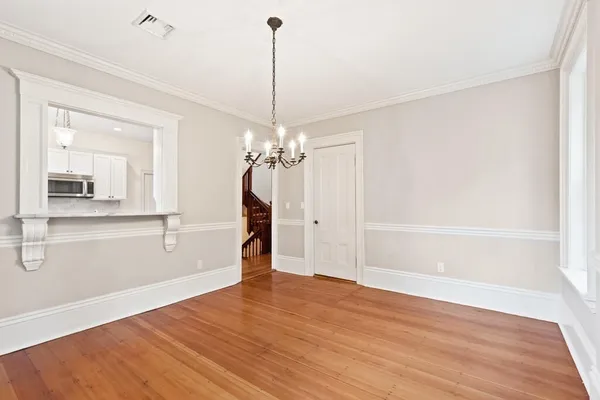a view of a room with wooden floor staircase and a kitchen