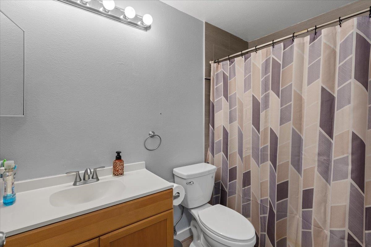 480 Kenolio Road, Unit 1103 Kihei, HI 96753 - Photo 17 of 32 a bathroom with a sink a toilet and shower curtain