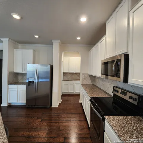 a kitchen with stainless steel appliances granite countertop a refrigerator and a stove top oven