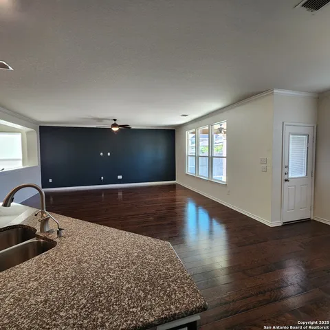 a bedroom with wooden floor and window