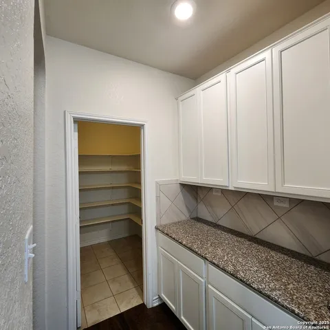 a kitchen with granite countertop a sink and a white cabinets