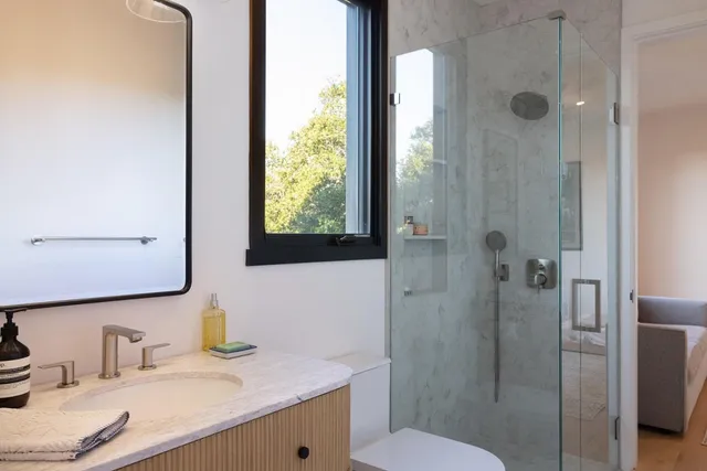 a bathroom with a granite countertop sink toilet and shower
