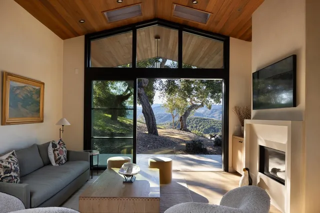 a living room with fireplace furniture and a floor to ceiling window