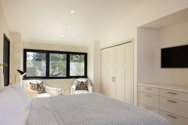 a bedroom with a bed and a large window