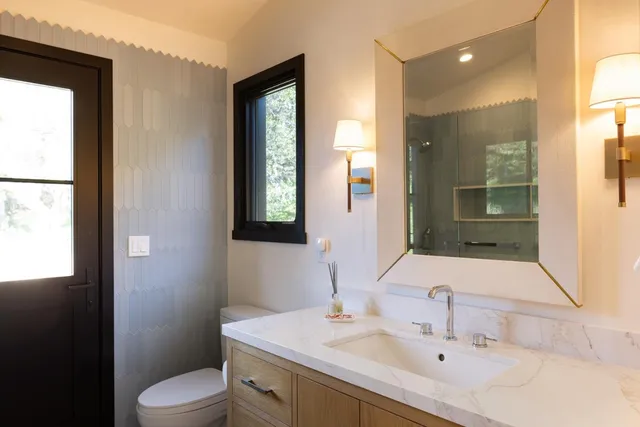 a bathroom with a sink toilet and mirror