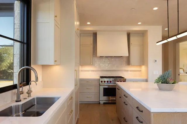 a kitchen with stainless steel appliances granite countertop a sink stove and refrigerator
