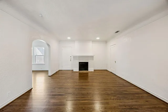 a view of a livingroom with wooden floor and a fireplace