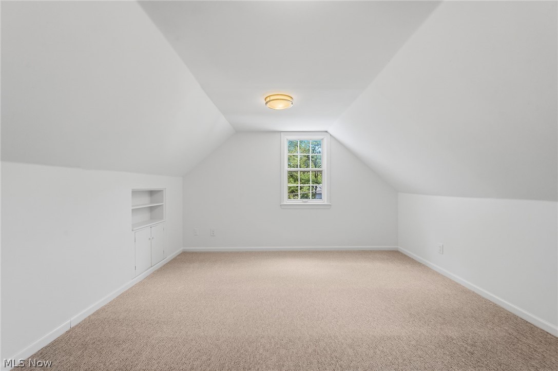 7750 Lewis Road Olmsted Falls, OH 44138 - Photo 31 of 50 Carpeted room featuring a double-hung window, built-in shelving, white walls, and a ceiling-mounted light fixture