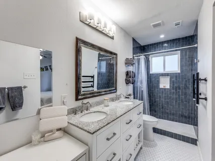 a spacious bathroom with a granite countertop tub sink a mirror a shower and vanity