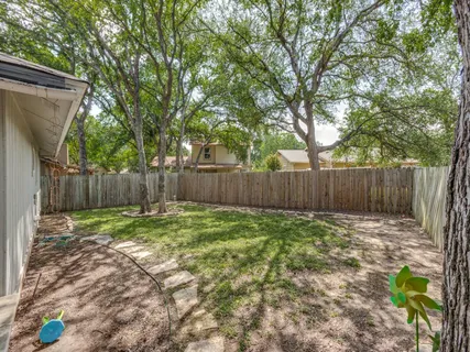 a backyard with table and chairs and wooden fence