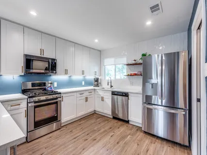 a kitchen with stainless steel appliances a refrigerator stove a sink and a microwave