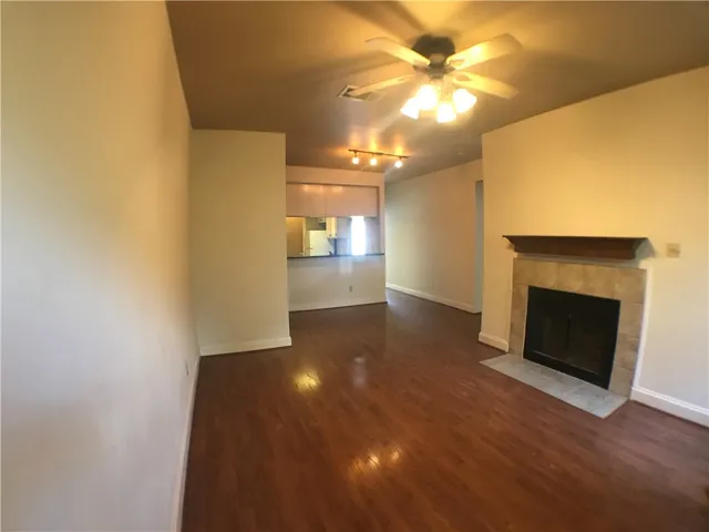 a view of a livingroom with a fireplace and a chandelier fan