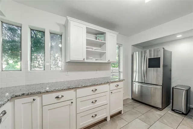 a kitchen with granite countertop a refrigerator and a sink