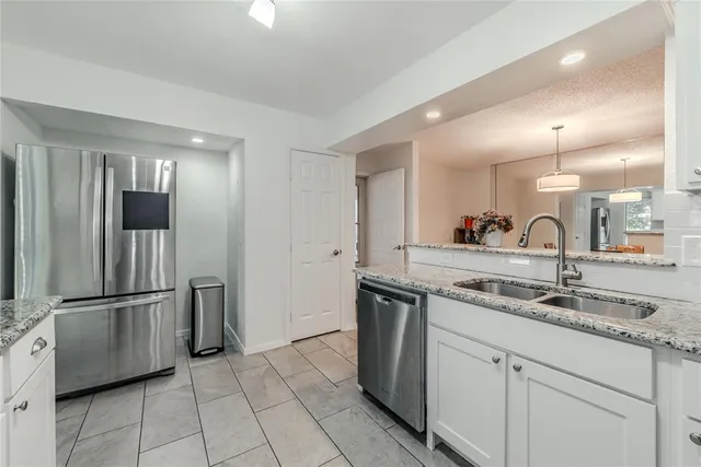 a kitchen with stainless steel appliances granite countertop a refrigerator and a sink