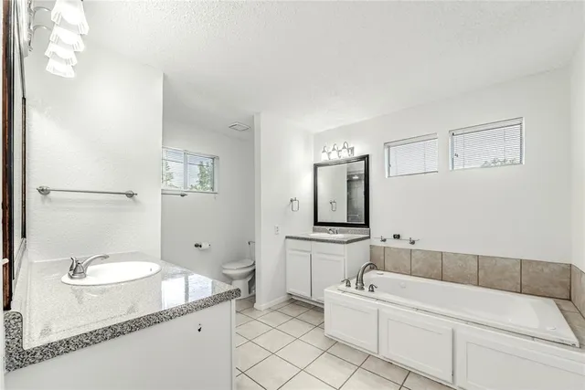 a bathroom with a granite countertop sink mirror and bathtub
