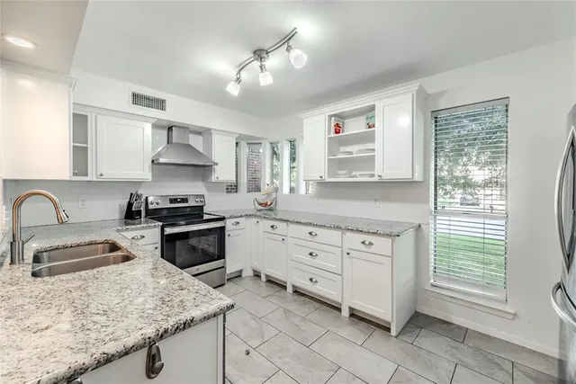 a kitchen with granite countertop a sink stainless steel appliances and window