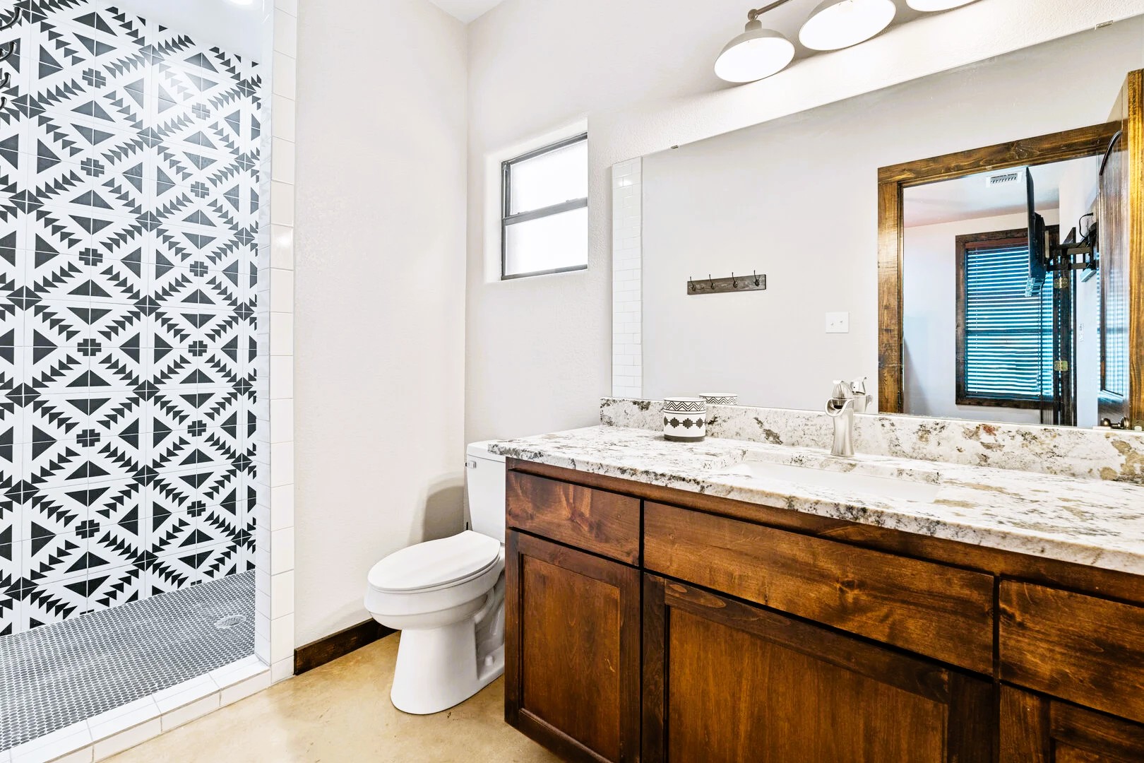 1718 Mountain Valley Road Concan, TX 78838 - Photo 16 of 40 A stylish vanity paired with patterned wall tile anchors this modern bathroom space.