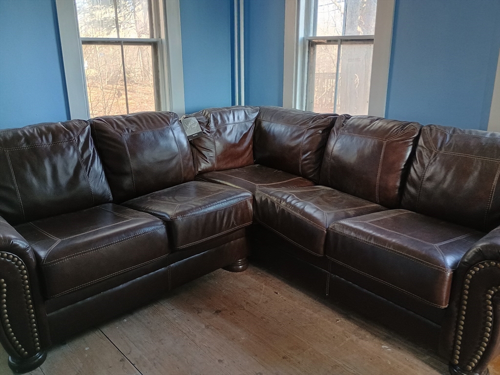 9 Olive Street Ashland, MA 01721 - Photo 13 of 33 a blue couch sitting in a living room next to a window