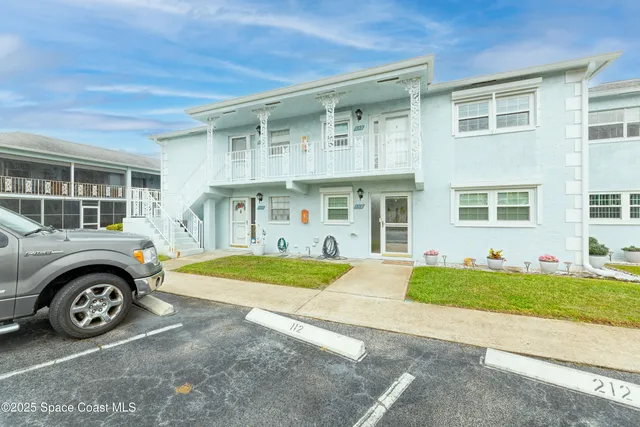 a front view of a house with a garden and parking space
