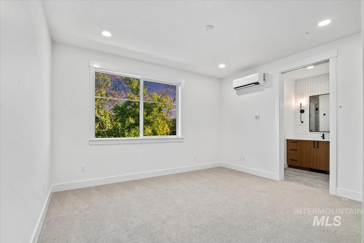 3249 West Moore Street Boise, ID 83702 - Photo 20 of 35 Unfurnished bedroom featuring light carpet, recessed lighting, ensuite bath, and an AC wall unit