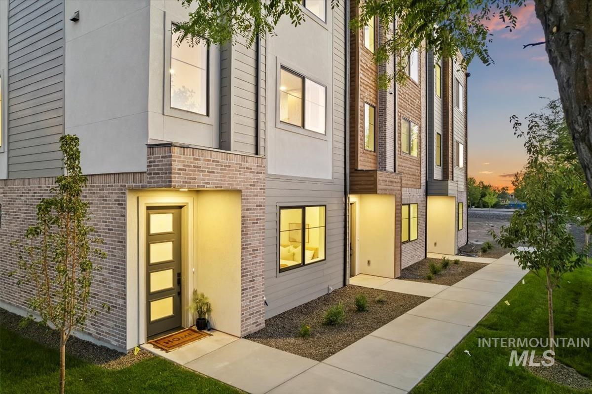 3249 West Moore Street Boise, ID 83702 - Photo 23 of 35 Exterior entry at dusk with brick siding and a lawn