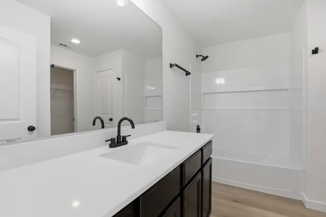 a view of empty room with wooden floor and ceiling fan