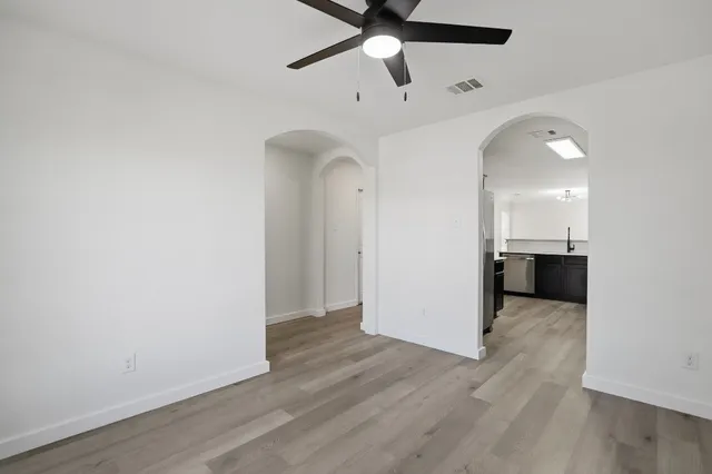 a kitchen with stainless steel appliances a refrigerator and a wooden floor