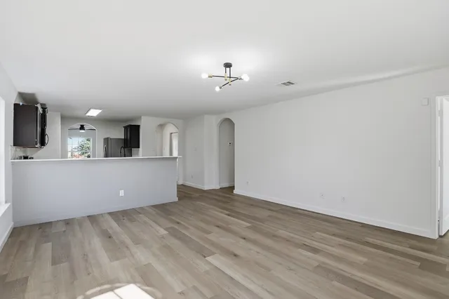 a view of a kitchen with wooden floor and electronic appliances