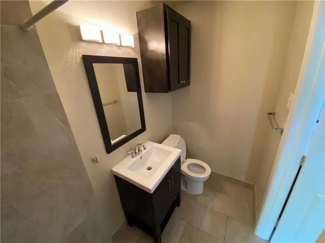 a bathroom with a toilet sink and mirror