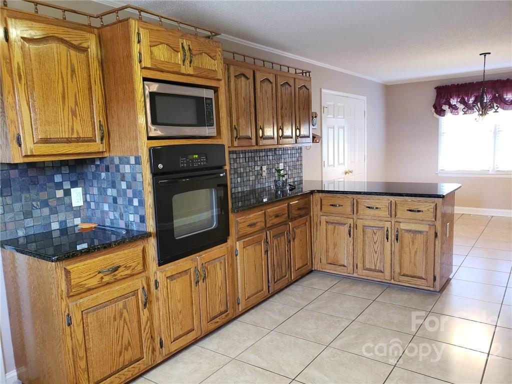 5418 East Lawyers Road Wingate, NC 28174 - Photo 12 of 40 a kitchen with stainless steel appliances granite countertop a stove a sink and a microwave