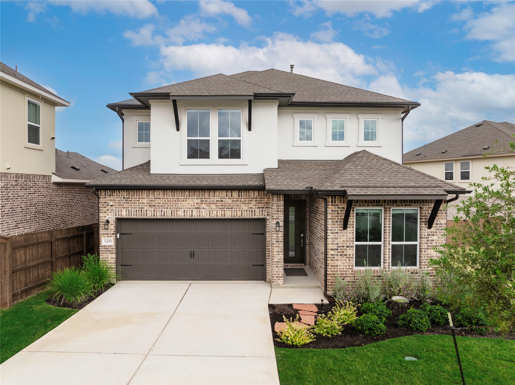 a front view of a house with a garden and garage