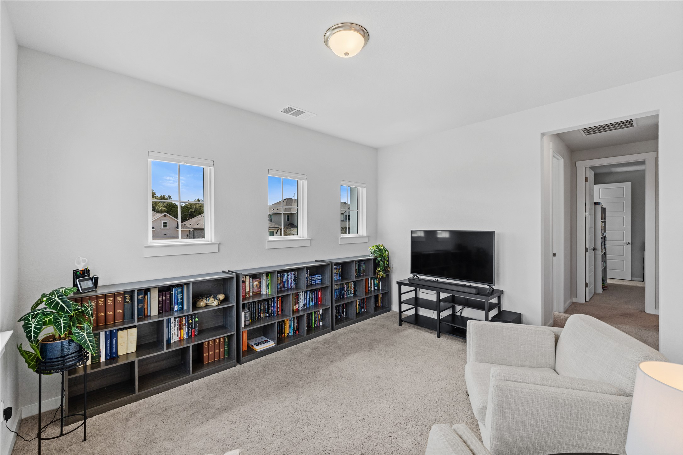 1209 Willie Rnch Way Leander, TX 78641 - Photo 19 of 37 a living room with furniture a flat screen tv and a book shelf