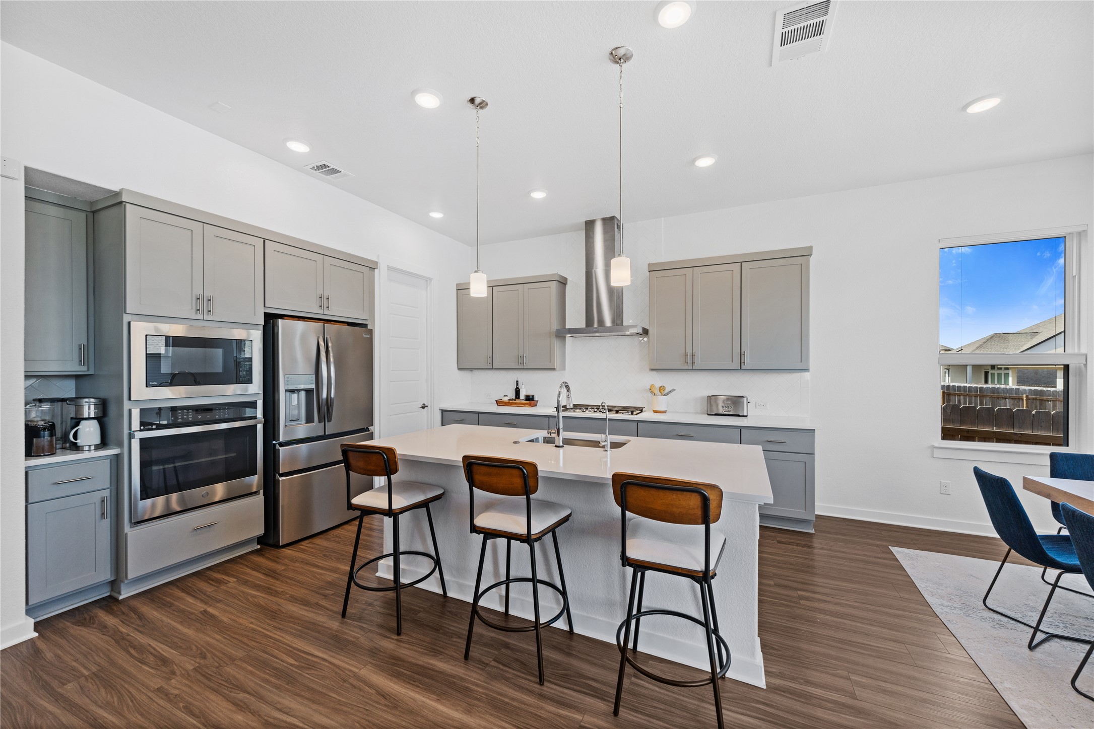 1209 Willie Rnch Way Leander, TX 78641 - Photo 7 of 37 a kitchen with stainless steel appliances granite countertop a stove a sink a refrigerator and chairs