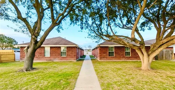 a front view of a house with yard tree and wooden fence