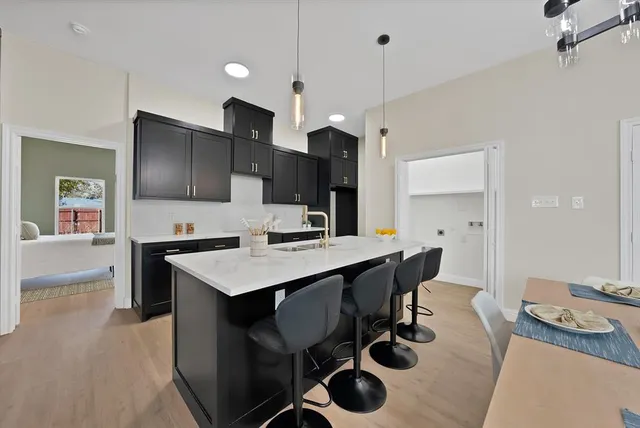 a kitchen with a table chairs refrigerator and microwave