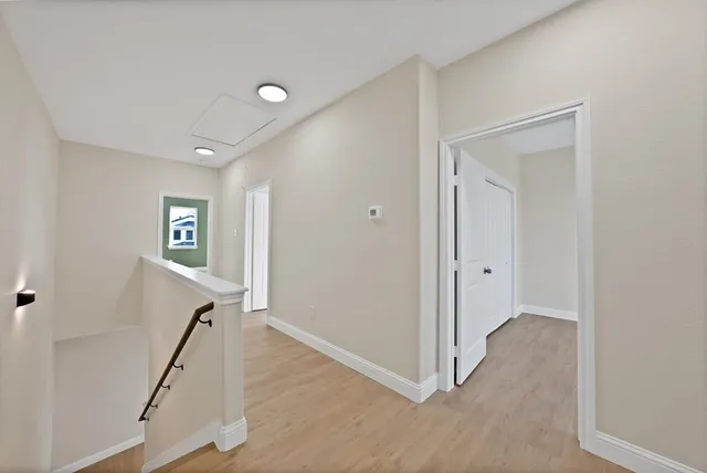 a view of a hallway with workspace and wooden floor