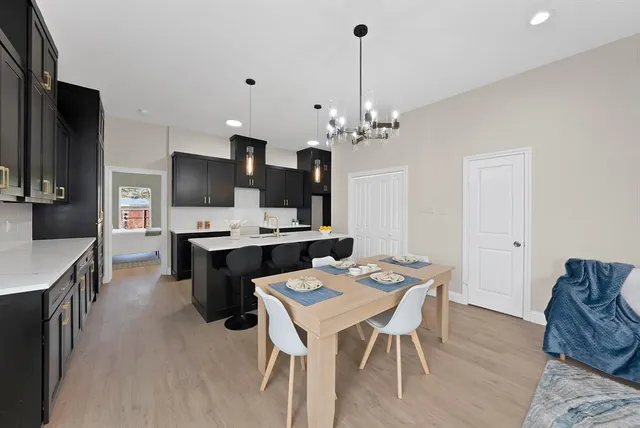 a kitchen with a dining table chairs sink and cabinets