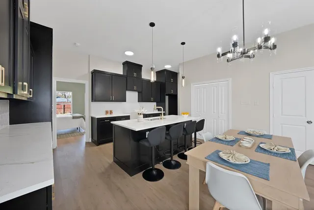 a large kitchen with kitchen island a stove a sink a table and chairs