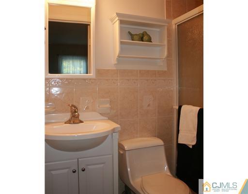 69 Dellwood Road Edison, NJ 08820 - Photo 8 of 9 a bathroom with a toilet a sink and mirror