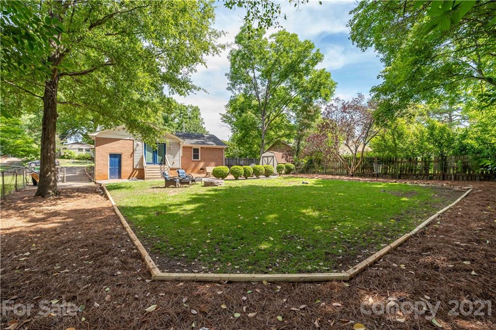 3854 Litchfield Road Charlotte, NC 28211 - Photo 20 of 35 a view of a white house in front of a big yard with plants and large trees