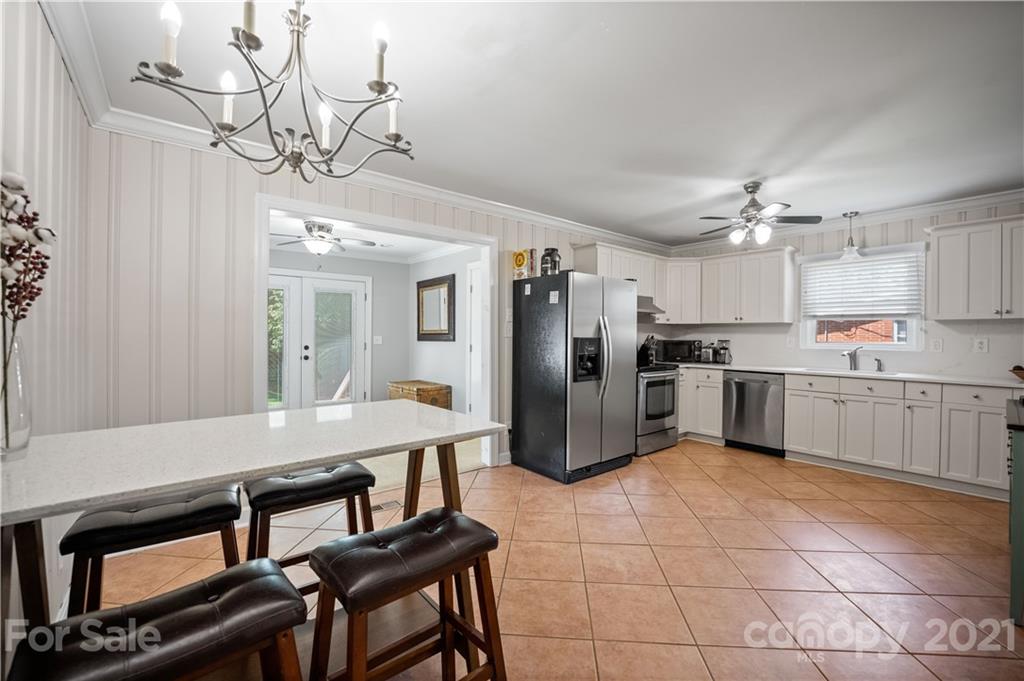 3854 Litchfield Road Charlotte, NC 28211 - Photo 6 of 35 a kitchen with stainless steel appliances a table chairs and a refrigerator