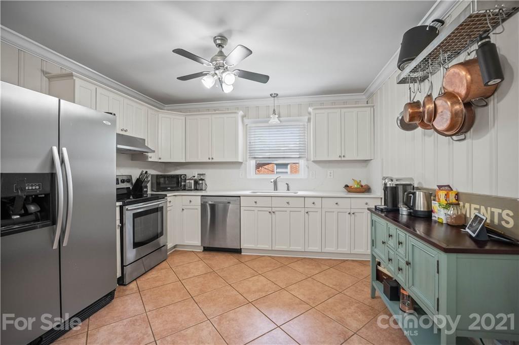 3854 Litchfield Road Charlotte, NC 28211 - Photo 7 of 35 a kitchen with cabinets a window and stainless steel appliances