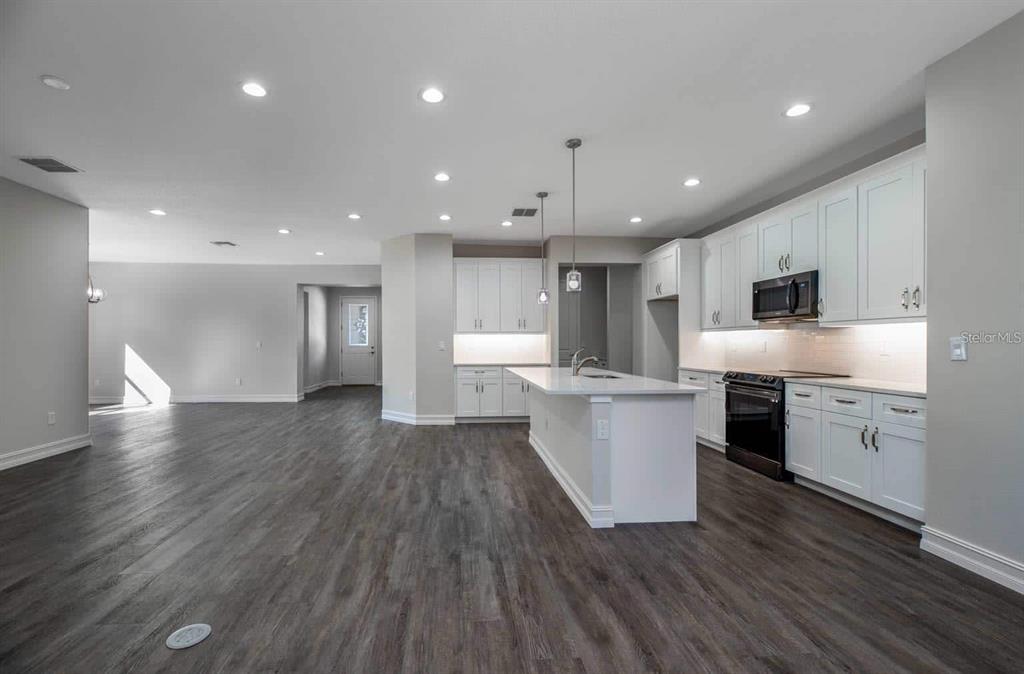 12133 Southwest 45 Street Ocala, FL 34481 - Photo 3 of 9 a large kitchen with a large counter top a sink stainless steel appliances and cabinets