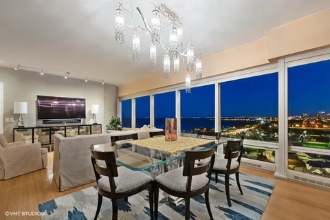 a view of a dining room with furniture a chandelier and wooden floor