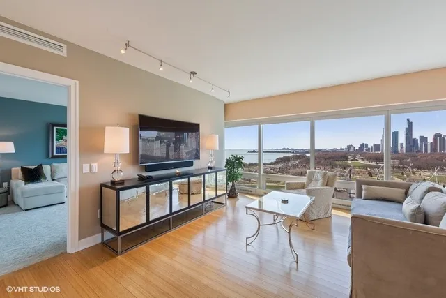a living room with furniture a rug and a floor to ceiling window
