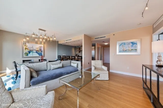 a living room with furniture and a chandelier