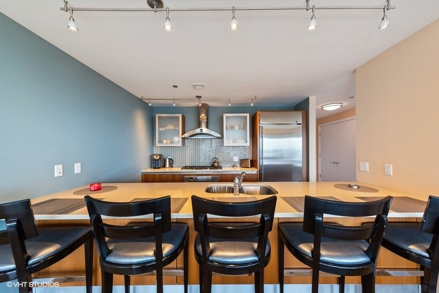340 East Randolph Street, Unit 905 Chicago, IL 60601 - Photo 6 of 31 a dining room with stainless steel appliances a table and chairs