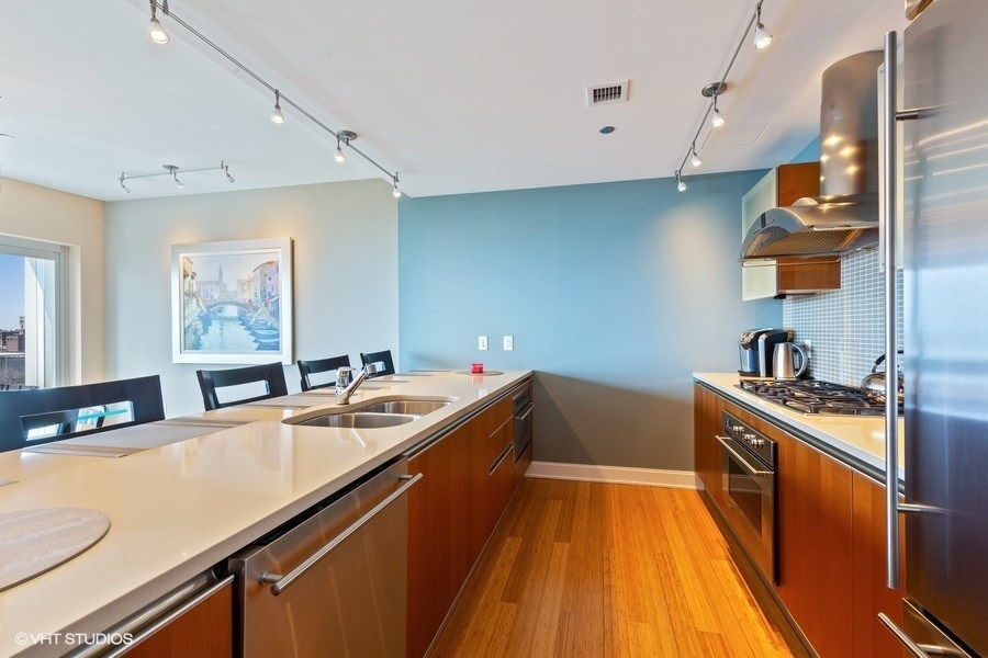 340 East Randolph Street, Unit 905 Chicago, IL 60601 - Photo 7 of 31 a kitchen with a sink a stove and cabinets