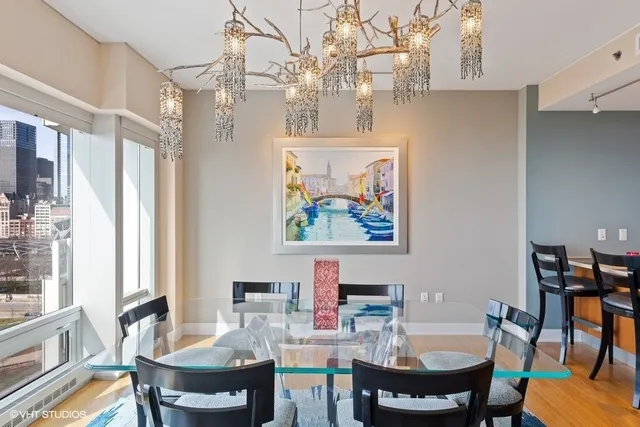 a view of a dining room with furniture a chandelier and wooden floor