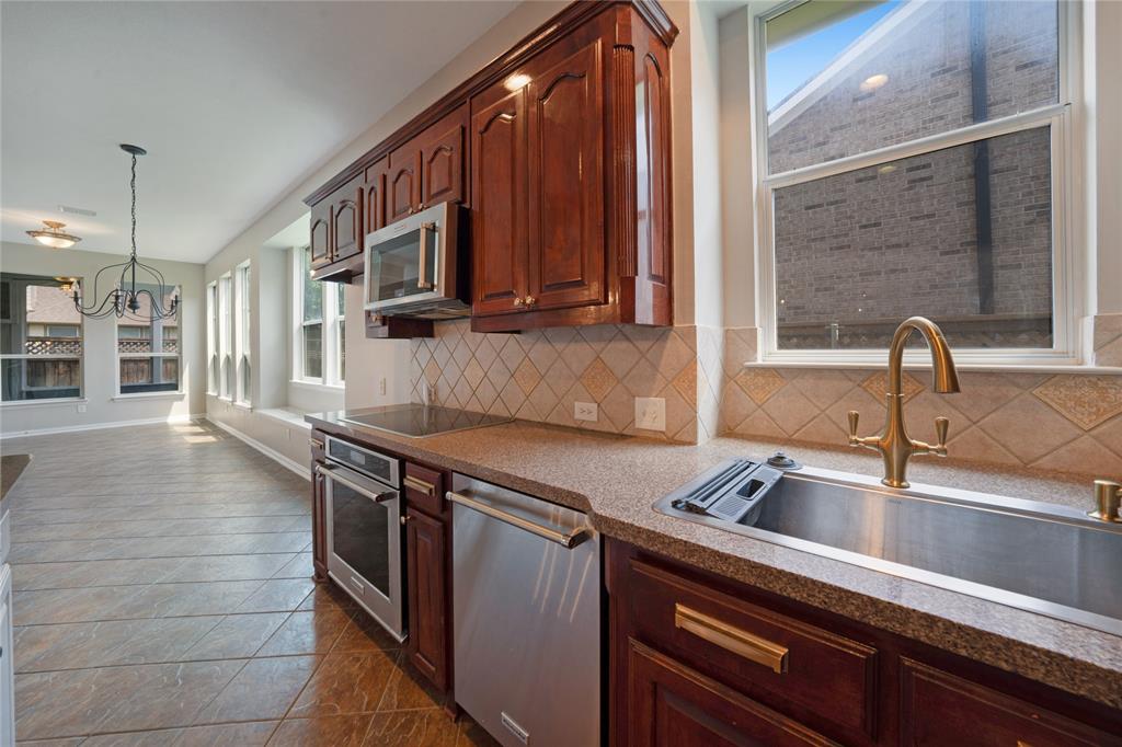 3418 Oakleigh Lane Frisco, TX 75033 - Photo 16 of 37 a kitchen with stainless steel appliances granite countertop a sink and a microwave
